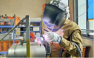 製造現場で製品を確認しながら打ち合わせをする3人のスタッフ
